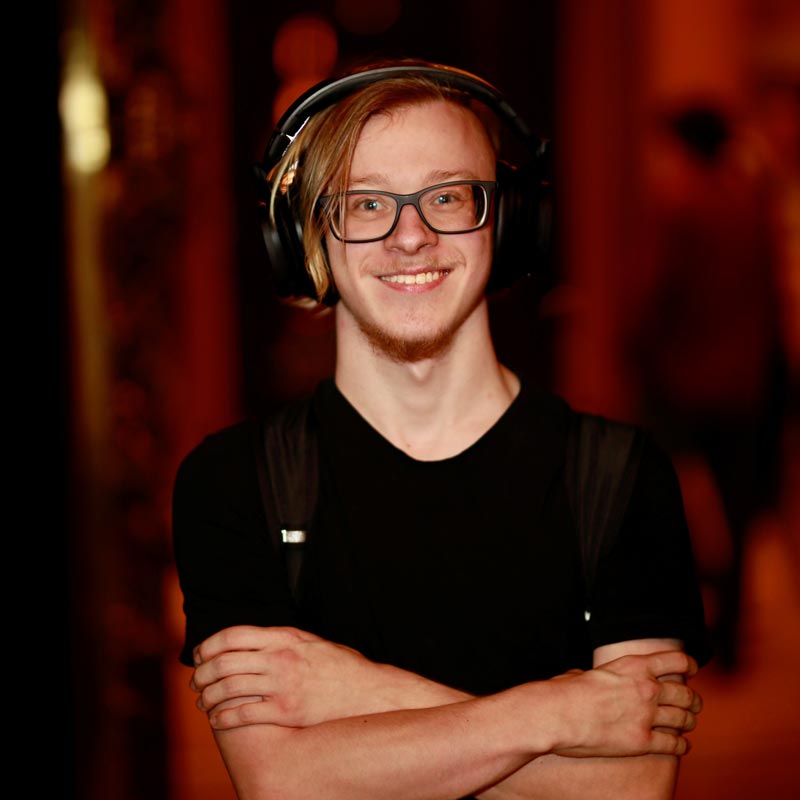 Porträt von Ben: blonder Mann mit Brille und Kopfhörern